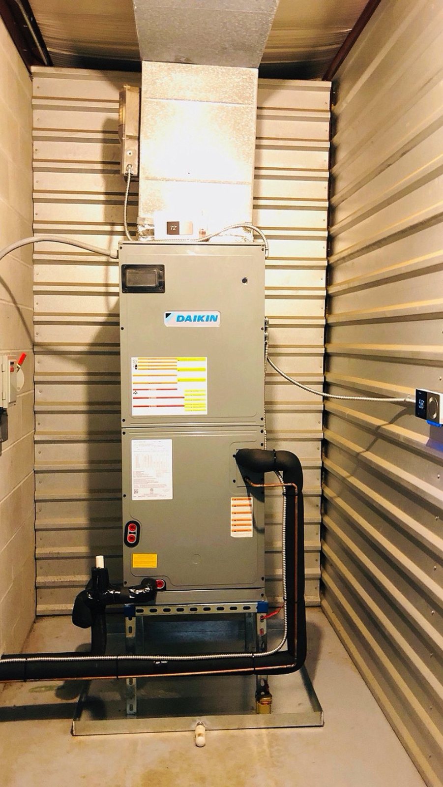 Daikin air handler serving a climate-controlled self-storage building in Houston, with insulated line set and thermostat