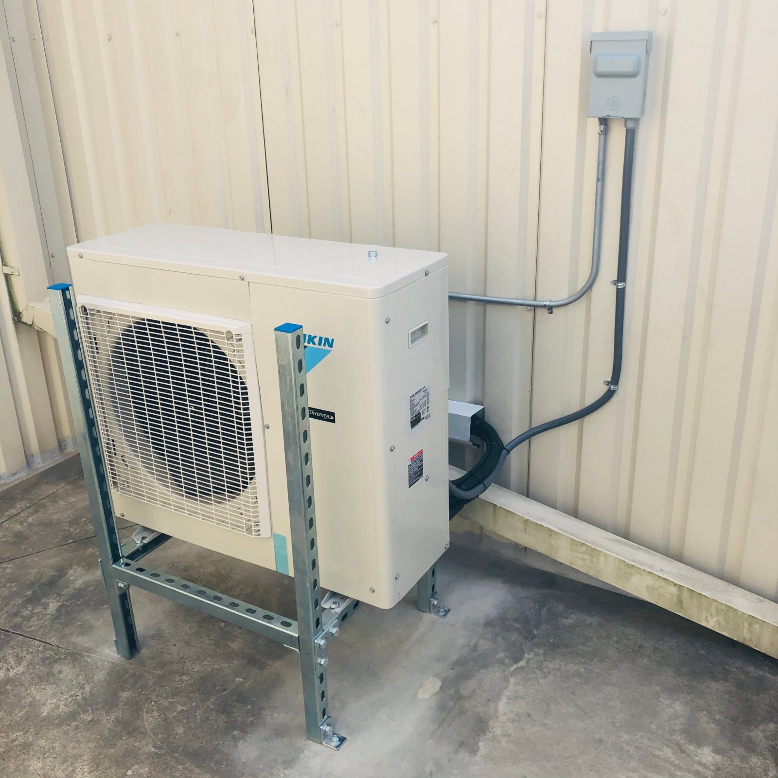 Daikin condenser on a galvanized Unistrut stand with dedicated disconnect and conduit for a Houston elevator machine room