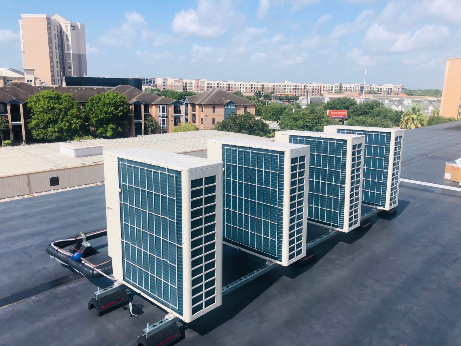 Four Daikin heat pump condensers on a rooftop Unistrut rail at a Houston self-storage building